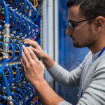 Low voltage technician working on fiber and structured cabling for data center infrastructure