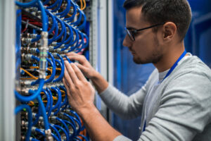 Low voltage technician working on fiber and structured cabling for data center infrastructure