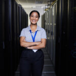 Data center staffing professional standing between rows of servers