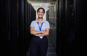 Data center staffing professional standing between rows of servers