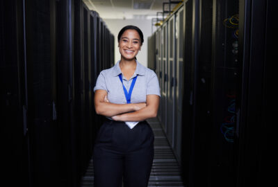 Data center staffing professional standing between rows of servers