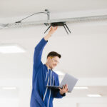 DAS technician installing in-building wireless equipment inside a commercial facility