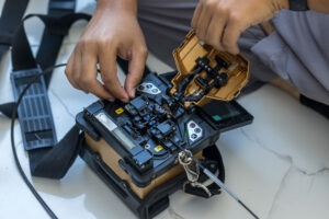 Fiber splicer preparing fiber optic cables for broadband network turn-up