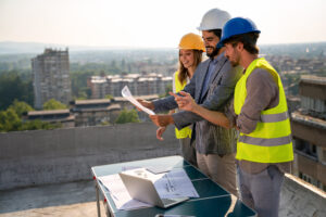 Site acquisition staffing team reviewing wireless deployment plans near telecom infrastructure