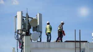 Tower construction manager staffing support for wireless crews reviewing build plans near a telecom tower