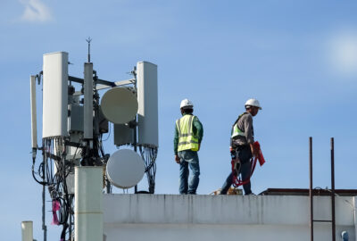 Tower construction manager staffing support for wireless crews reviewing build plans near a telecom tower