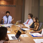 BEAD program manager reviewing broadband deployment plans with a cross-functional infrastructure team