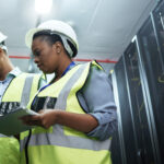 Data center team lead reviewing operations with a technician
