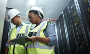 Data center team lead reviewing operations with a technician