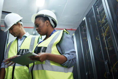 Data center team lead reviewing operations with a technician