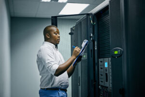 DC power technician inspecting UPS battery systems in a data center power room