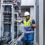 Data center technician inspecting liquid cooling equipment before high-density workloads go live
