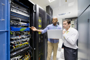 Data center maintenance manager reviewing critical facility systems with a technician