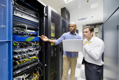 Data center maintenance manager reviewing critical facility systems with a technician