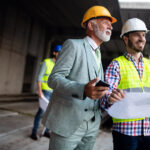 Project manager reviewing data center construction plans with engineers on site