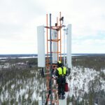 Microwave engineer working near wireless backhaul equipment on a telecom tower