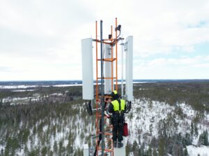 Microwave engineer working near wireless backhaul equipment on a telecom tower