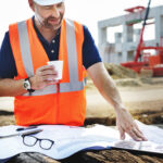 OSP engineer reviewing fiber network plans near an outside plant construction route