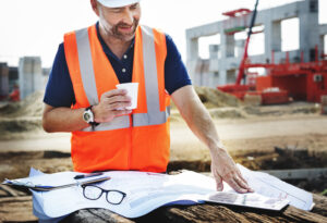 OSP engineer reviewing fiber network plans near an outside plant construction route