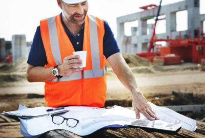 OSP engineer reviewing fiber network plans near an outside plant construction route