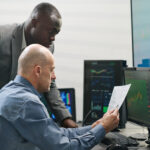 RF optimization manager reviewing 5G network performance with wireless engineers