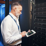 Data center reliability engineer inspecting critical infrastructure with a tablet