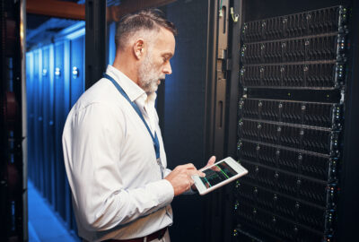 Data center reliability engineer inspecting critical infrastructure with a tablet