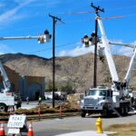 Aerial fiber lineman in a bucket truck installing fiber optic cable on a utility pole during a broadband build