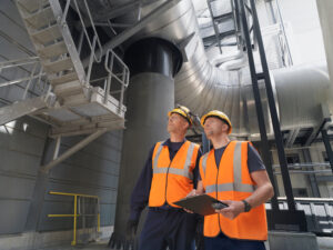 Technicians in safety gear inspecting on-site gas turbine generators that supply power to a data center campus