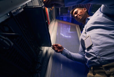 Technician servicing a server rack inside a small edge data center