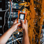 Fiber test technician using an optical test set to check fiber optic links before network acceptance